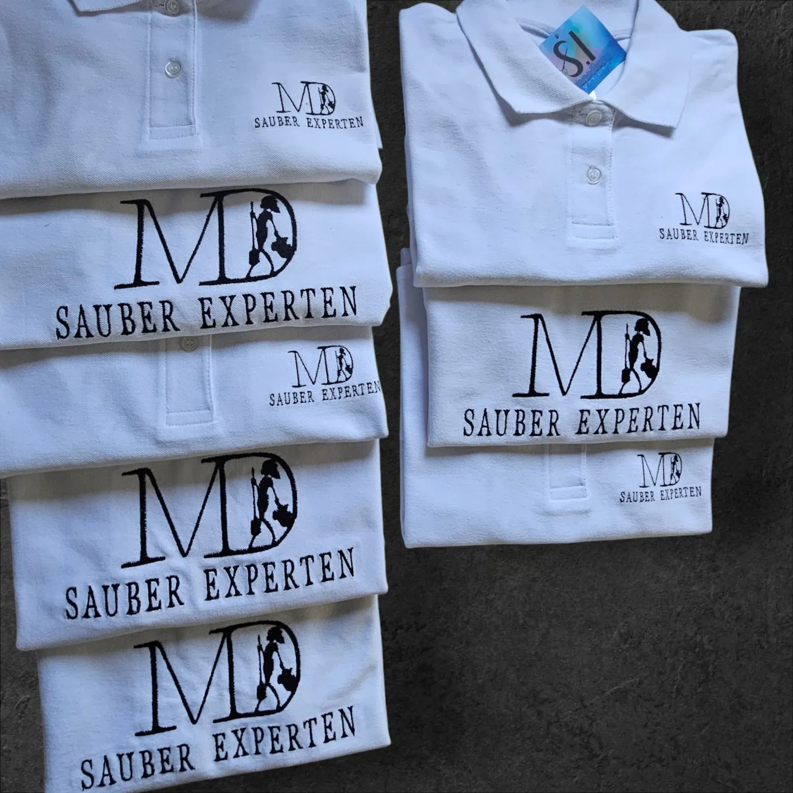 Gestickte Firmenlogos für MD Sauber Experten auf weißen Poloshirts
